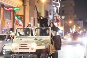 مجندات «إيرانيات» يحملن أسلحة ثقيلة وبنادق آلية داخل مركبة عسكرية في شوارع طهران