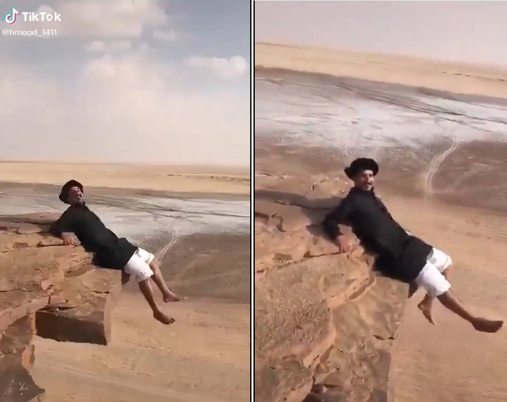شاهد: شاب سعودي يغامر بالجلوس على حافة جبل شاهق