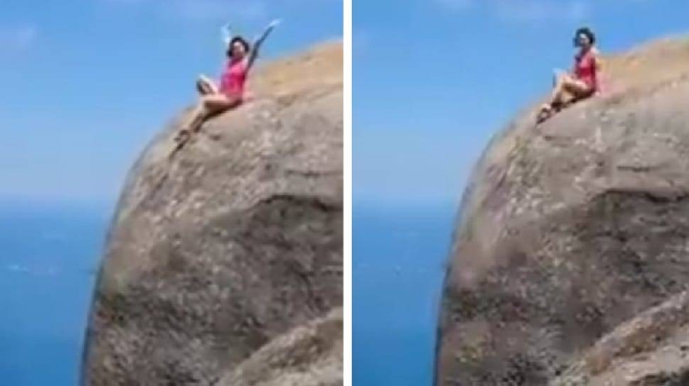 شاهد.. رجل يوثق فيديو لزوجته وهي تجلس على قمة جبل ويطلب منها التقدم أكثر