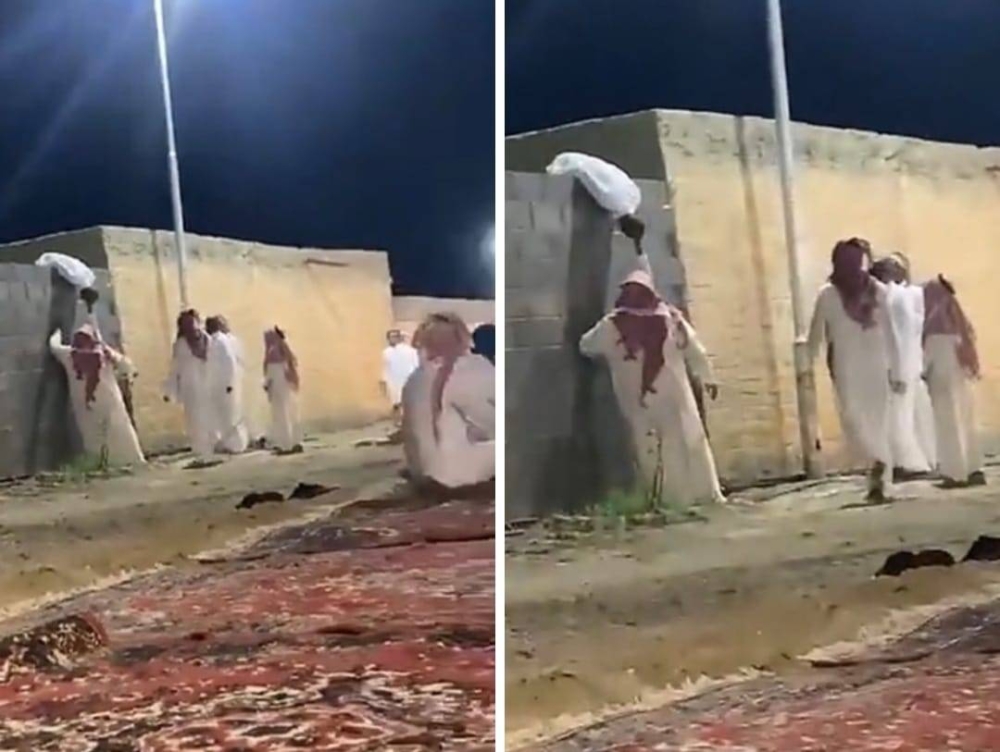 شاهد.. شاب يعتلي جدار ويهز رأسه بطريقة غريبة أثناء حفل غنائي ويثير الجدل