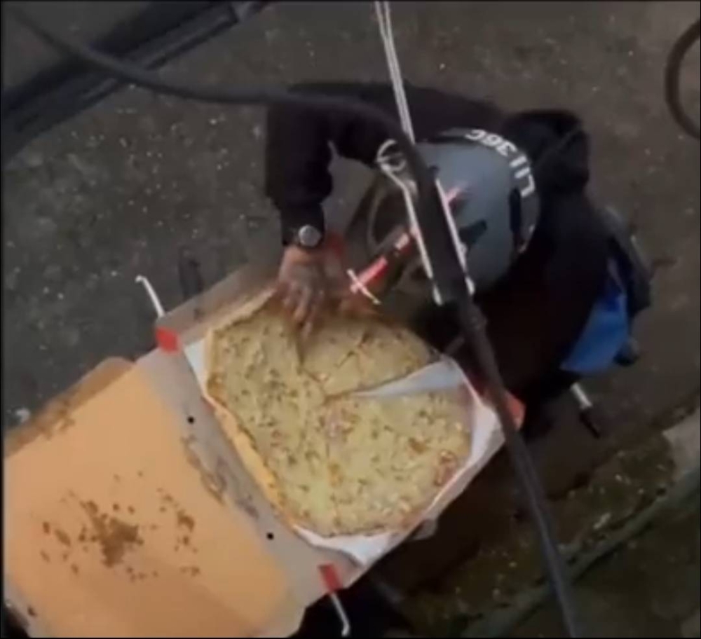 شاهد .. عامل توصيل يأكل قطعة من البيتزا التي يقوم بتوصيلها ويعيد ترتيبها كأنها جديدة بمهارة عالية !