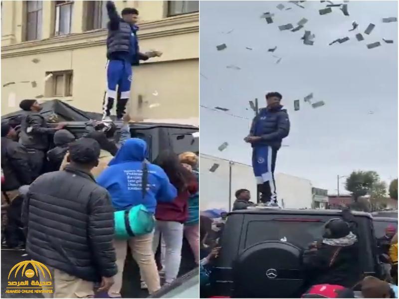 شاهد.. مغني راب أمريكي يقف فوق سيارته ويلقي الأموال على الفقراء في لوس أنجلوس