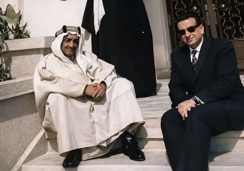 صورة نادرة للملك فيصل جالسًا على درج قصر بالرياض.. والكشف عن تاريخ التقاطها وهوية الشخص الذي ظهر بجانبه